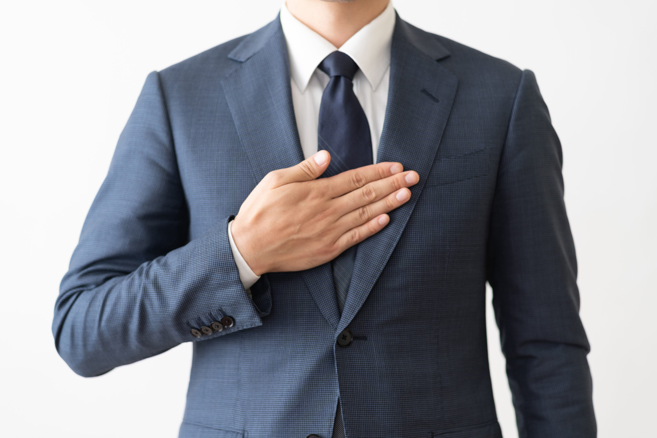 胸に手を当てている男性